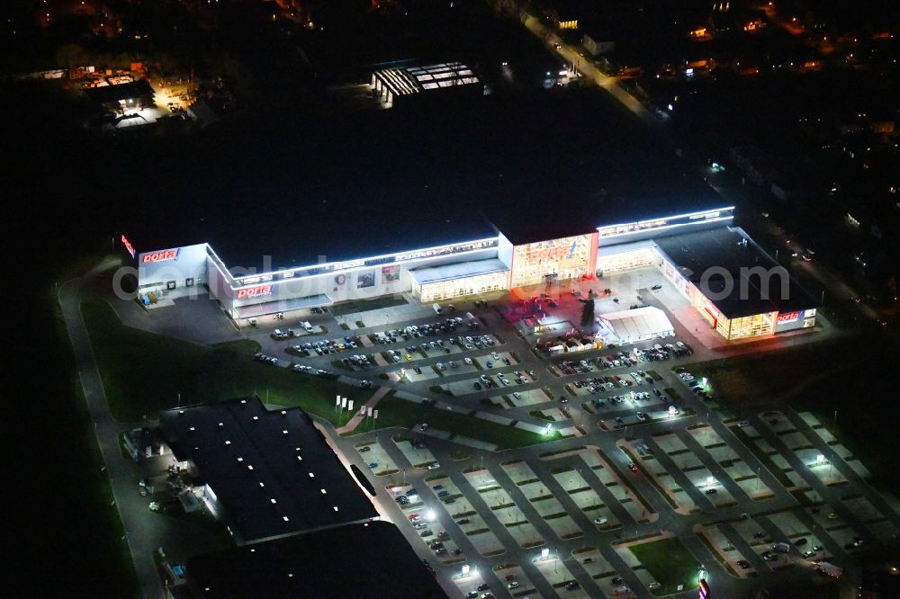 Aerial image at night Berlin - Night lighting site for the new building home-center of the Porta-Group at Pilgramer street in the district Mahlsdorf in Berlin