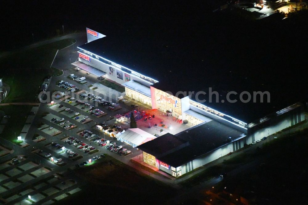 Aerial image at night Berlin - Night lighting site for the new building home-center of the Porta-Group at Pilgramer street in the district Mahlsdorf in Berlin