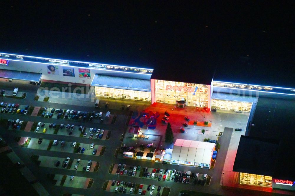 Aerial image at night Berlin - Night lighting site for the new building home-center of the Porta-Group at Pilgramer street in the district Mahlsdorf in Berlin