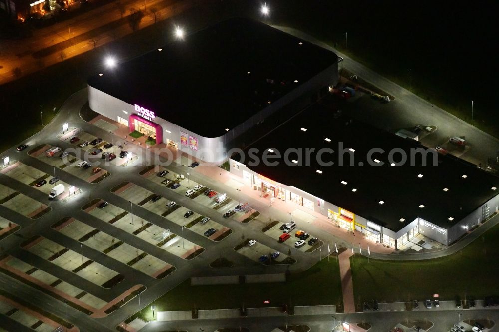 Berlin at night from the bird perspective: Night lighting site for the new building home-center of the Porta-Group at Pilgramer street in the district Mahlsdorf in Berlin