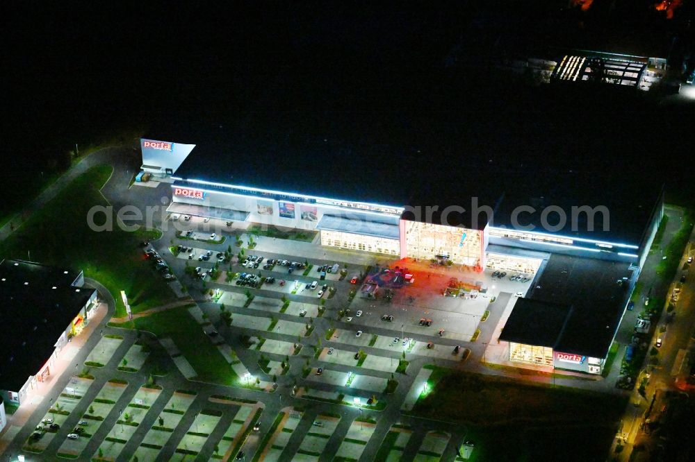 Aerial image at night Berlin - Night lighting site for the new building home-center of the Porta-Group at Pilgramer street in the district Mahlsdorf in Berlin