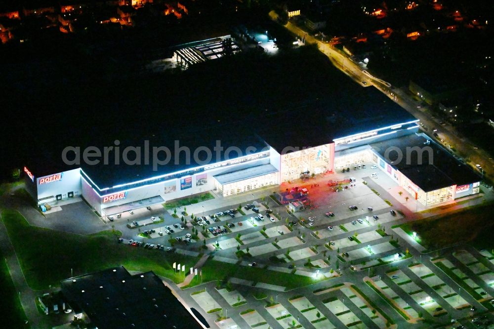 Aerial photograph at night Berlin - Night lighting site for the new building home-center of the Porta-Group at Pilgramer street in the district Mahlsdorf in Berlin