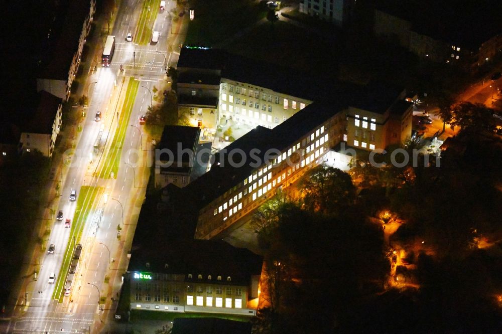 Aerial image at night Berlin - Night lighting residential area of a multi-family house settlement Treskow-Hoefe on Treskowallee corner Hoenower Strasse in the district Karlshorst in Berlin, Germany