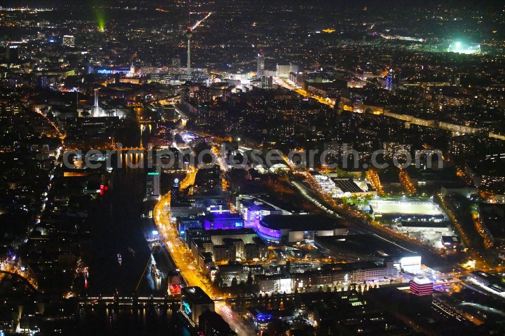 Berlin at night from the bird perspective: Night lighting Arena Mercedes-Benz-Arena on Friedrichshain part of Berlin. The former O2 World - now Mercedes-Benz-Arena - is located in the Anschutz Areal, a business and office space on the riverbank