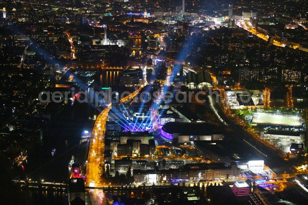 Aerial image at night Berlin - Night lighting Arena Mercedes-Benz-Arena on Friedrichshain part of Berlin. The former O2 World - now Mercedes-Benz-Arena - is located in the Anschutz Areal, a business and office space on the riverbank