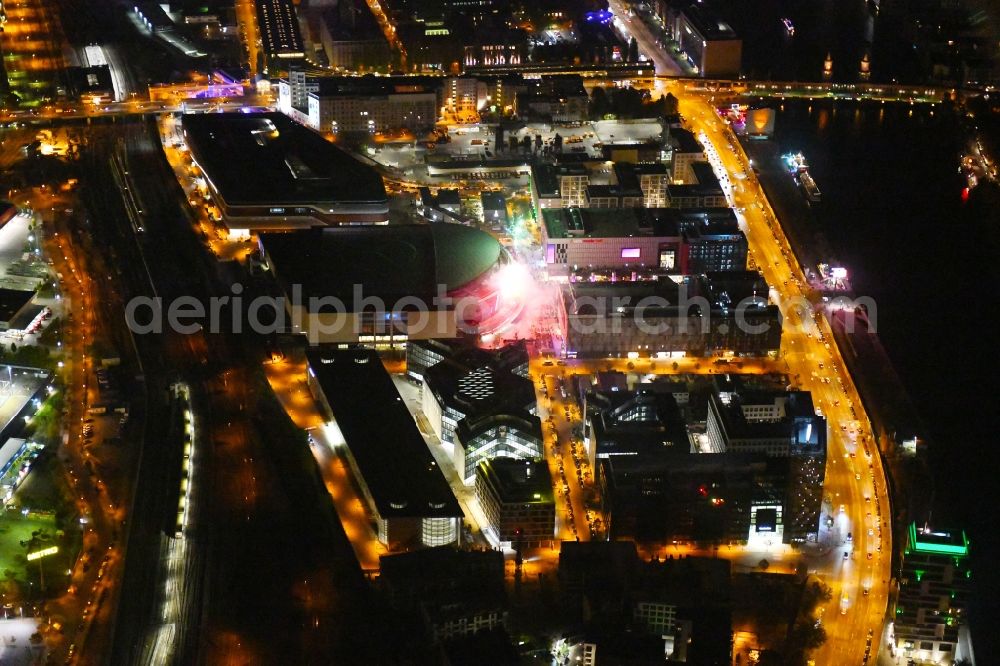 Aerial image at night Berlin - Night lighting Arena Mercedes-Benz-Arena on Friedrichshain part of Berlin. The former O2 World - now Mercedes-Benz-Arena - is located in the Anschutz Areal, a business and office space on the riverbank