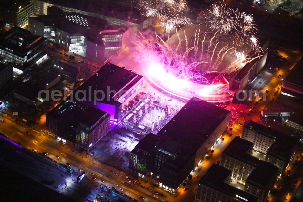 Berlin at night from the bird perspective: Night lighting Arena Mercedes-Benz-Arena on Friedrichshain part of Berlin. The former O2 World - now Mercedes-Benz-Arena - is located in the Anschutz Areal, a business and office space on the riverbank