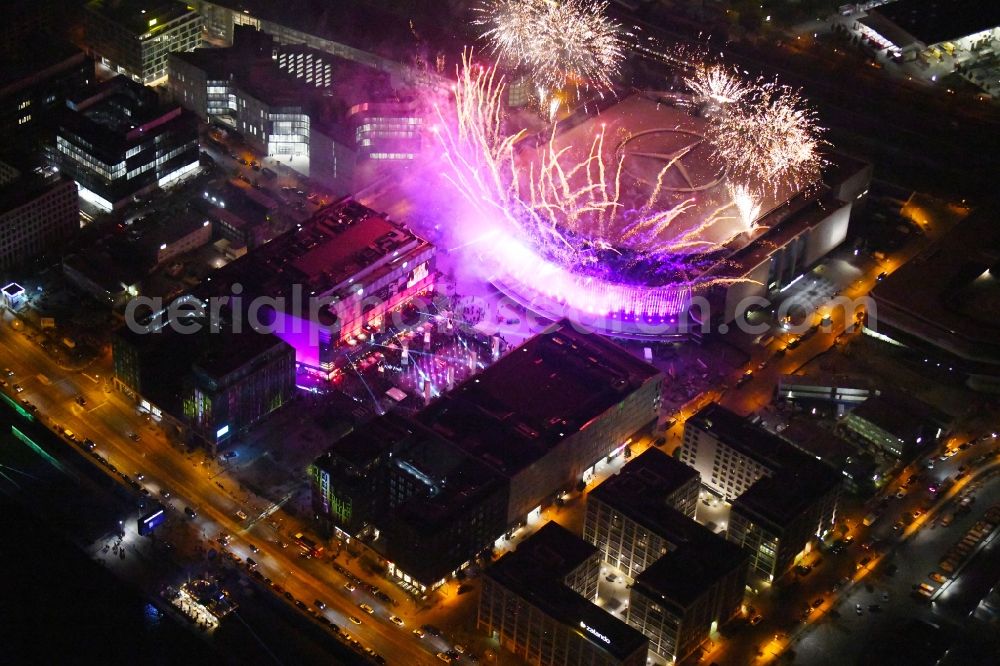 Berlin at night from the bird perspective: Night lighting Arena Mercedes-Benz-Arena on Friedrichshain part of Berlin. The former O2 World - now Mercedes-Benz-Arena - is located in the Anschutz Areal, a business and office space on the riverbank