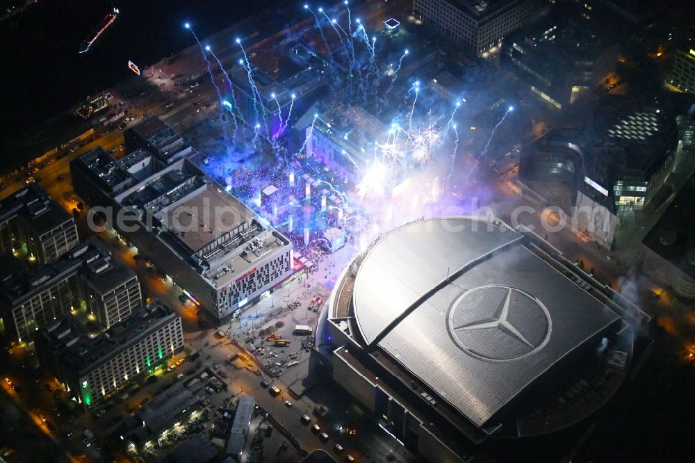 Berlin at night from the bird perspective: Night lighting Arena Mercedes-Benz-Arena on Friedrichshain part of Berlin. The former O2 World - now Mercedes-Benz-Arena - is located in the Anschutz Areal, a business and office space on the riverbank