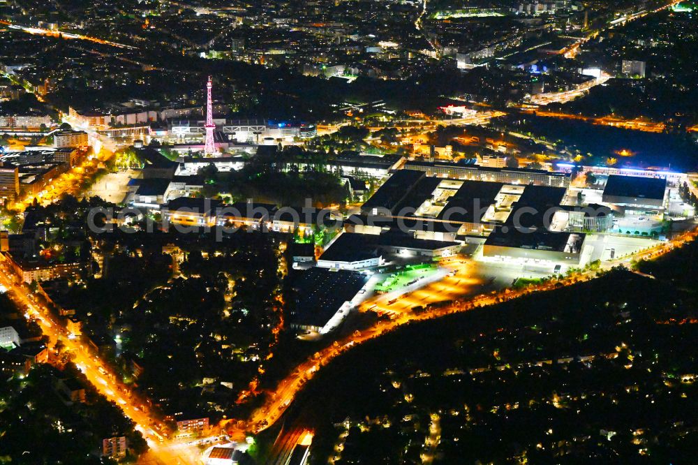 Aerial image at night Berlin - Night lighting exhibition grounds and exhibition halls on Funkturm - Messedamm - Kongresszentrum ICC and the highway and motorway crosssing A100 to A115 in the district Charlottenburg in Berlin, Germany