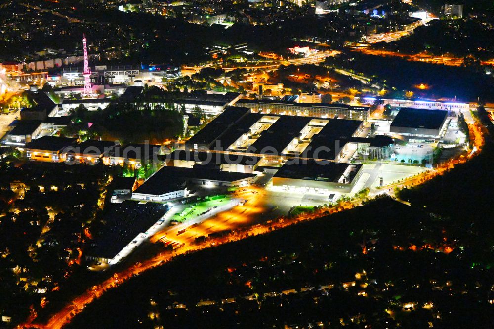 Berlin at night from the bird perspective: Night lighting exhibition grounds and exhibition halls on Funkturm - Messedamm - Kongresszentrum ICC and the highway and motorway crosssing A100 to A115 in the district Charlottenburg in Berlin, Germany