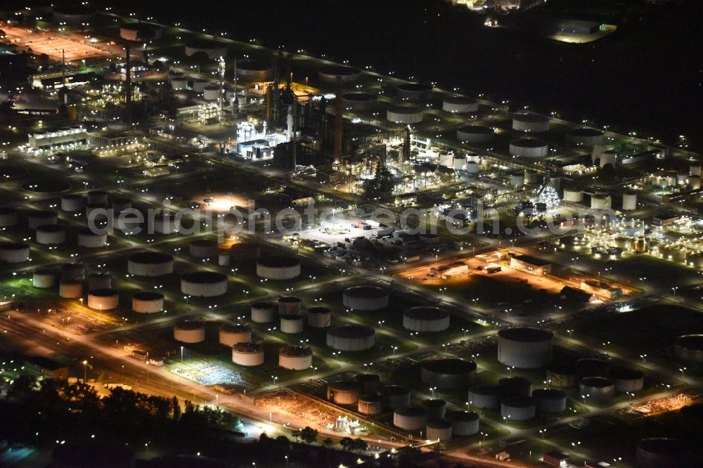 Aerial image at night Hamburg - Mineral oil - tank illuminated at night in the port area on the banks of the Elbe in Hamburg