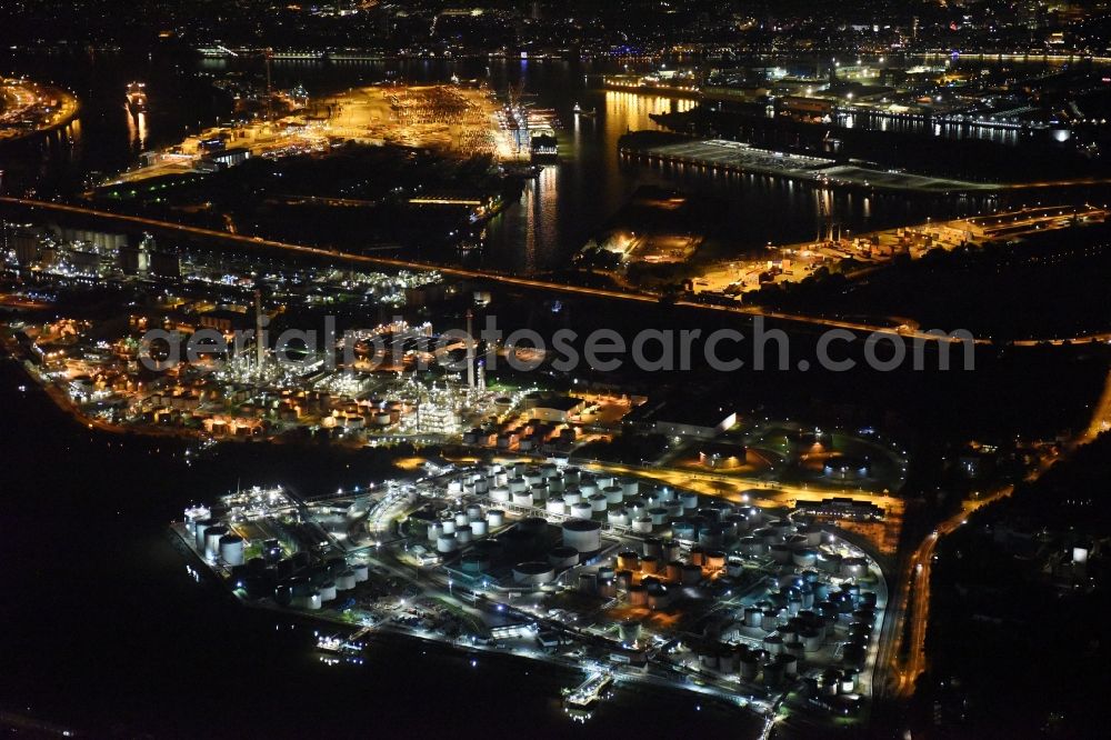 Aerial photograph at night Hamburg - Mineral oil - tank illuminated at night in the port area on the banks of the Elbe in Hamburg