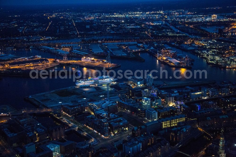 Aerial image at night Hamburg - Night aerial view overlooking the HafenCity on the banks of the Norderelbe with Speicherstadt, Strandkai, Southwest Harbor and sailing ship harbor. The Harbour City is a Hamburg district completely surrounded by channels and rivers, which also includes the historic Speicherstadt with the former Elbe Peninsular Kehrwieder