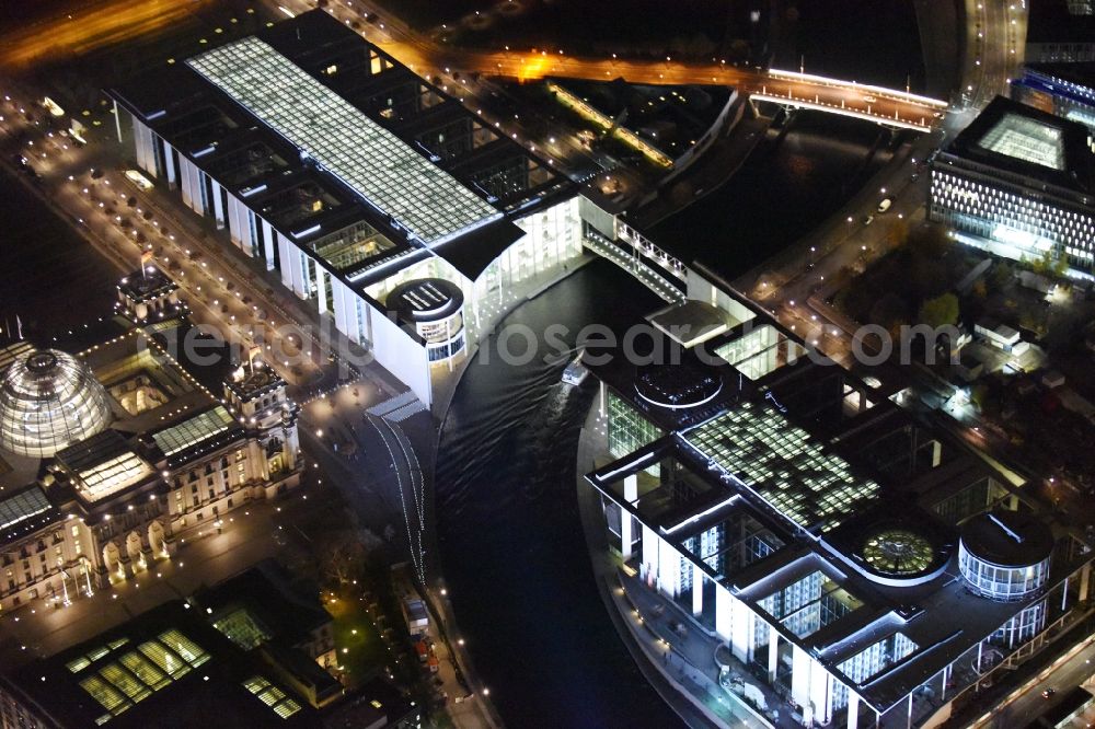 Aerial image at night Berlin - Night shot of the Reichstag in Berlin-Mitte and the Paul-Loebe-Haus, a function building of the German Federal Parliament, at the oxbow Spreebogen in the government quarter in Berlin-Mitte