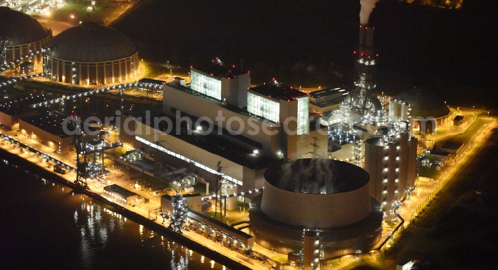 Hamburg at night from the bird perspective: Night view Coal power plants of the Vattenfall power plant Moorburg in Hamburg in Germany. The power plant with its domes, silos and technical facilities is located on the riverbank of the Suederelbe