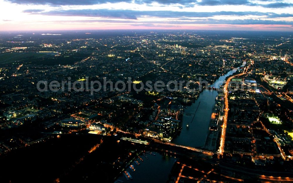 Aerial photograph at night Berlin Friedrichshain Treptow - Night city view of downtown along the east bank of the Spree on high-rise Treptowers in the district of Treptow - Friedrichshain in Berlin