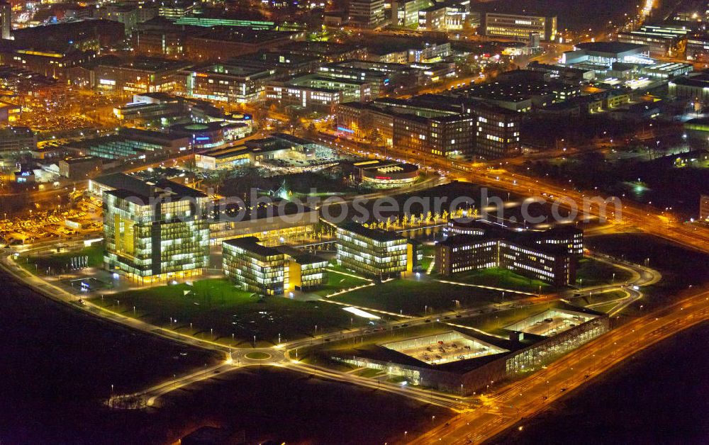 Essen at night from the bird perspective: Nachtaufnahme vom Areal des ThyssenKrupp Hauptquartier als Kern des Krupp-Gürtels in Essen. Im Hintergrund die Stadtansicht vom Stadtzentrum der Rhurmetropole. Auf dem zwischen 1945 und 2007 größtenteils brachliegenden Gelände der ehemaligen Kruppschen Gussstahlfabrik, die im Zweiten Weltkrieg teils zerstört, die Reste später demontiert und nicht wieder aufgebaut wurden, ist das Hauptquartier der ThyssenKrupp AG (Krupp und Thyssen fusionierten 1999) am 17. Juni 2010 offiziell eröffnet worden. The Thyssen House in the newly established ensemble of ThyssenKrupp's headquarters as the core of the Krupp Belt in Essen.