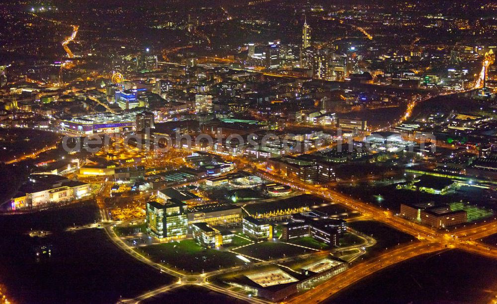 Aerial photograph at night Essen - Nachtaufnahme vom Areal des ThyssenKrupp Hauptquartier als Kern des Krupp-Gürtels in Essen. Im Hintergrund die Stadtansicht vom Stadtzentrum der Rhurmetropole. Auf dem zwischen 1945 und 2007 größtenteils brachliegenden Gelände der ehemaligen Kruppschen Gussstahlfabrik, die im Zweiten Weltkrieg teils zerstört, die Reste später demontiert und nicht wieder aufgebaut wurden, ist das Hauptquartier der ThyssenKrupp AG (Krupp und Thyssen fusionierten 1999) am 17. Juni 2010 offiziell eröffnet worden. The Thyssen House in the newly established ensemble of ThyssenKrupp's headquarters as the core of the Krupp Belt in Essen.