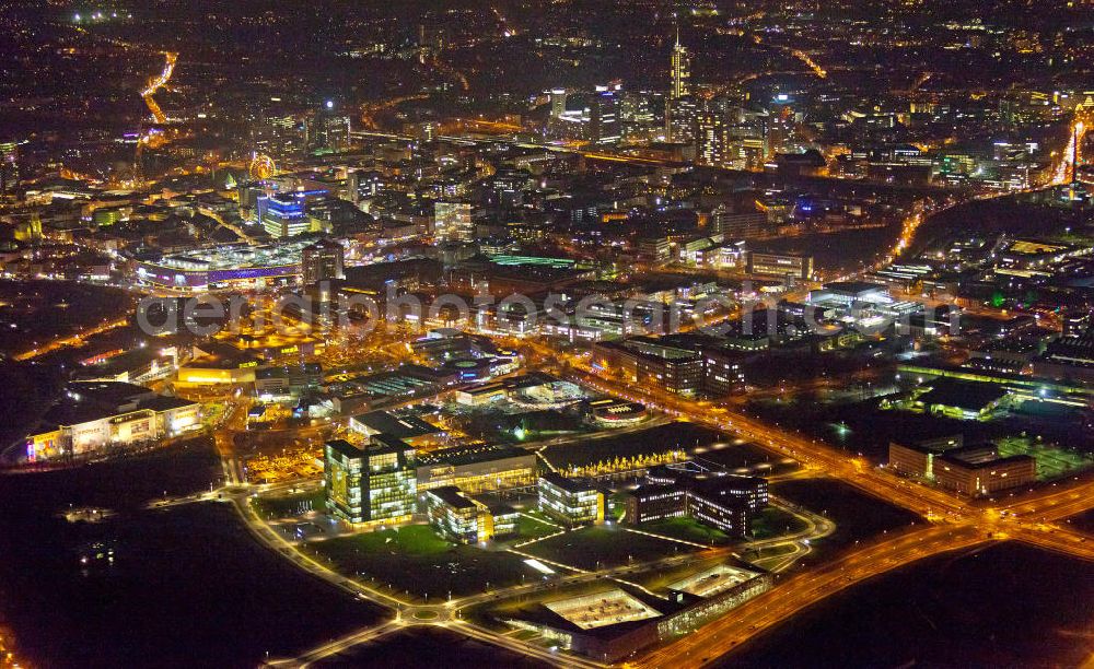 Aerial image at night Essen - Nachtaufnahme vom Areal des ThyssenKrupp Hauptquartier als Kern des Krupp-Gürtels in Essen. Im Hintergrund die Stadtansicht vom Stadtzentrum der Rhurmetropole. Auf dem zwischen 1945 und 2007 größtenteils brachliegenden Gelände der ehemaligen Kruppschen Gussstahlfabrik, die im Zweiten Weltkrieg teils zerstört, die Reste später demontiert und nicht wieder aufgebaut wurden, ist das Hauptquartier der ThyssenKrupp AG (Krupp und Thyssen fusionierten 1999) am 17. Juni 2010 offiziell eröffnet worden. The Thyssen House in the newly established ensemble of ThyssenKrupp's headquarters as the core of the Krupp Belt in Essen.