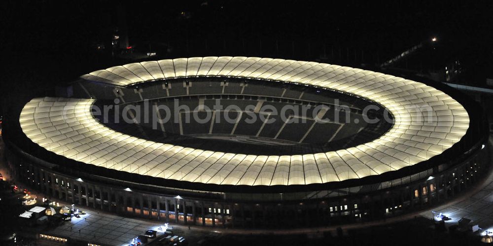 Berlin at night from the bird perspective: Nachtaufnahme des Berliner Olympiastadions. Das Stadion wurde von 1934 bis 1936 anlässlich der Olympischen Sommerspiele 1936 mit einem Fassungsvermögen von 100.000 Zuschauern nach Plänen des Architekten Werner March erbaut. View of the Berlin Olympic stadium at night.