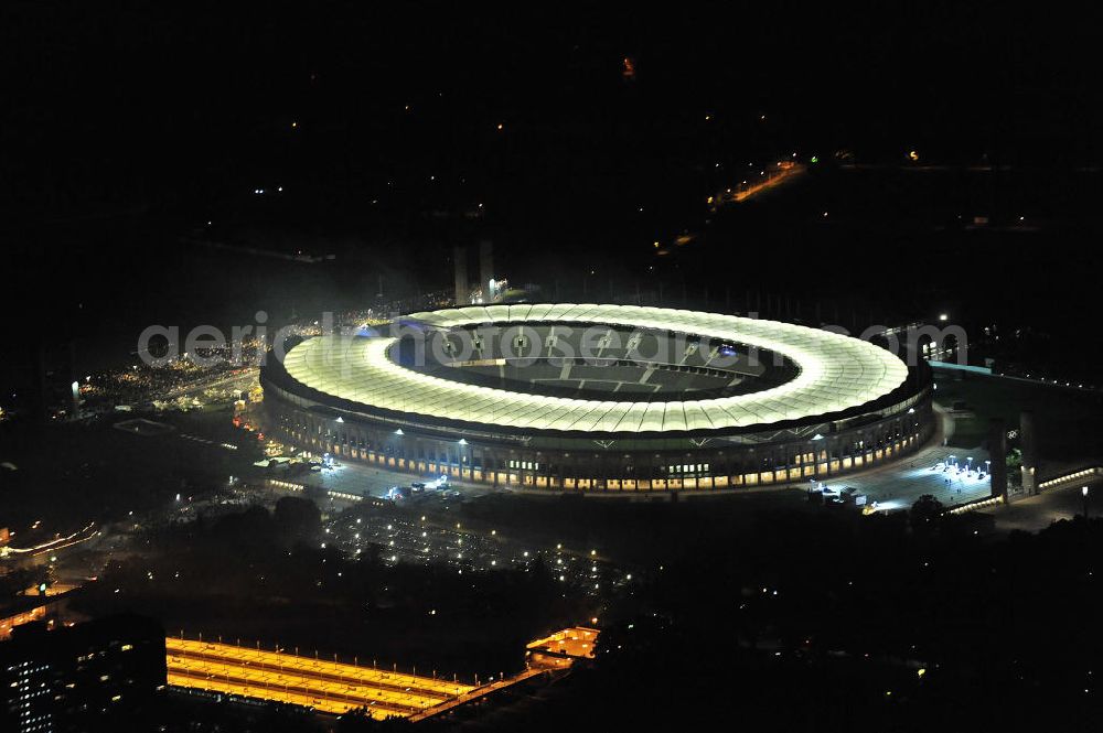 Aerial image at night Berlin - Nachtaufnahme des Berliner Olympiastadions. Das Stadion wurde von 1934 bis 1936 anlässlich der Olympischen Sommerspiele 1936 mit einem Fassungsvermögen von 100.000 Zuschauern nach Plänen des Architekten Werner March erbaut. View of the Berlin Olympic stadium at night.