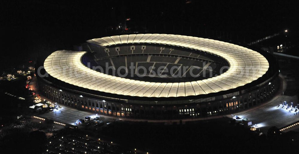 Berlin at night from the bird perspective: Nachtaufnahme des Berliner Olympiastadions. Das Stadion wurde von 1934 bis 1936 anlässlich der Olympischen Sommerspiele 1936 mit einem Fassungsvermögen von 100.000 Zuschauern nach Plänen des Architekten Werner March erbaut. View of the Berlin Olympic stadium at night.