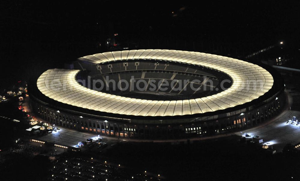 Aerial image at night Berlin - Nachtaufnahme des Berliner Olympiastadions. Das Stadion wurde von 1934 bis 1936 anlässlich der Olympischen Sommerspiele 1936 mit einem Fassungsvermögen von 100.000 Zuschauern nach Plänen des Architekten Werner March erbaut. View of the Berlin Olympic stadium at night.