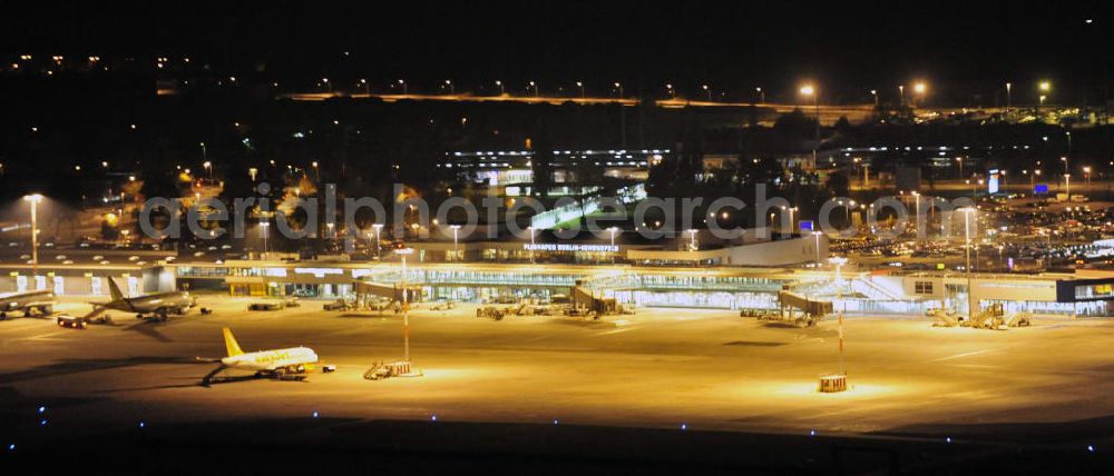 Schönefeld at night from the bird perspective: Nachtaufnahme: Sicht auf die Abfertigungshalle am Flughafen Berlin-Schönefeld. Wenn der Flughafen BBI in absehbarer Zeit in Betrieb geht, wird dieser Bereich überflüssig. Im Gespräch ist eine Weiternutzung des Abfertigungsbereiches zum Empfangsbereich für die Regierungsfliegerstaffel der Bundesregierung. Nightshot: View to the terminal building of the Berlin-Schönefeld Airport. The reconstruction to the BBI is non-completed.