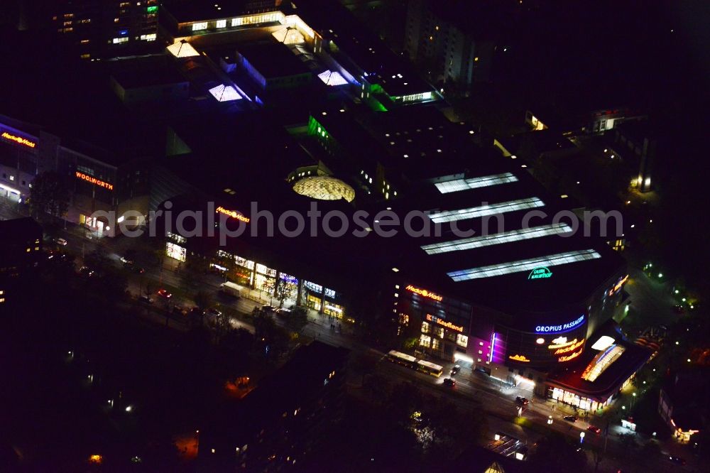 Berlin Neukölln at night from the bird perspective: Night aerial view from the shopping center Gropiuspassagen coherent with night lighting. The development, general planning, leasing and long-term management of Gropiuspassagen lie in the hands of the mfi management fuer immobilien AG. The shopping center is located in the Neukoelln district at the Johannisthaler Chaussee in Berlin