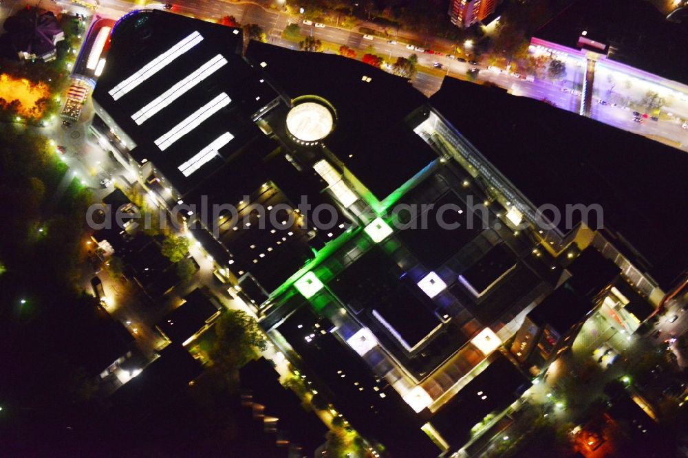 Berlin Neukölln at night from the bird perspective: Night aerial view from the shopping center Gropiuspassagen coherent with night lighting. The development, general planning, leasing and long-term management of Gropiuspassagen lie in the hands of the mfi management fuer immobilien AG. The shopping center is located in the Neukoelln district at the Johannisthaler Chaussee in Berlin