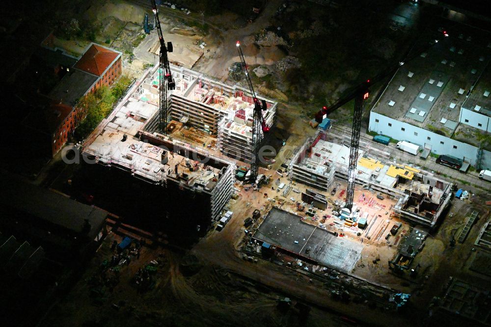 Berlin at night from the bird perspective: Night lighting construction site to build a new office and commercial building SIEMENSSTADT SQUARE on street Gartenfelder Strasse in the district Siemensstadt in Berlin, Germany