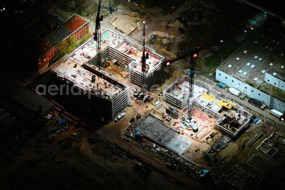 Aerial photograph at night Berlin - Night lighting construction site to build a new office and commercial building SIEMENSSTADT SQUARE on street Gartenfelder Strasse in the district Siemensstadt in Berlin, Germany