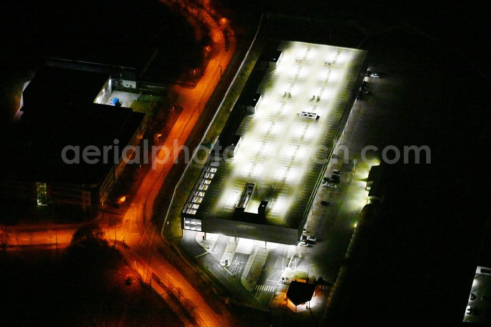 Aerial image at night München - Night lighting parking deck on the building of the car park on Alois-Wolfmueller-Strasse in the district Schwabing-Freimann in Munich in the state Bavaria, Germany