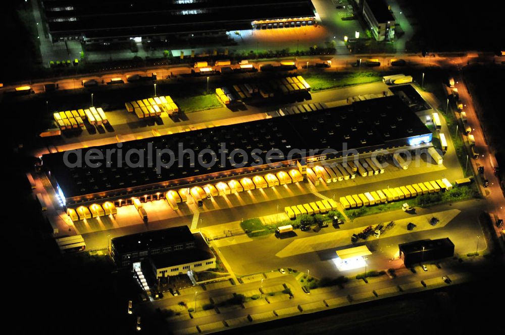 Schönefeld bei Berlin at night from the bird perspective: Nachtluftbild des Logistikzentrums Berlin Brandenburg der Firma Dachser GmbH & Co. KG in der Thomas-Dachser-Allee in Schönefeld. Im Hintergrund die Niederlassung Produktion Brief Berlin SO der Deutschen Post AG in der Straße In den Gehren. Night shot of the logistics centre Berlin Brandenburg of the company Dachser GmbH & Co. KG and a loading area of the Deutsche Post AG.