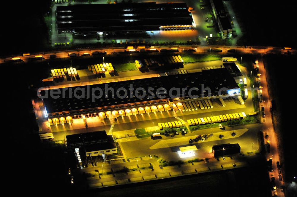 Aerial image at night Schönefeld bei Berlin - Nachtluftbild des Logistikzentrums Berlin Brandenburg der Firma Dachser GmbH & Co. KG in der Thomas-Dachser-Allee in Schönefeld. Im Hintergrund die Niederlassung Produktion Brief Berlin SO der Deutschen Post AG in der Straße In den Gehren. Night shot of the logistics centre Berlin Brandenburg of the company Dachser GmbH & Co. KG and a loading area of the Deutsche Post AG.