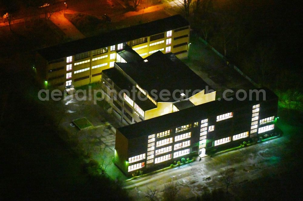 Aerial photograph at night Halle (Saale) - Night lighting School building of the Zweite Integrierte Gesamtschule Halle - 2.IGS on Rigaer Strasse in Halle (Saale) in the state Saxony-Anhalt, Germany