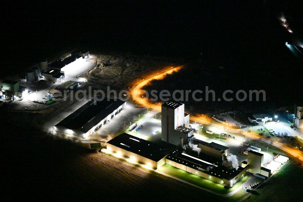 Aerial photograph at night Heidegrund - Night lighting high silo and grain storage with adjacent storage Thueringer Muehlenwerke GmbH on Muehlenstrasse in the district Weickelsdorf in Heidegrund in the state Saxony-Anhalt, Germany