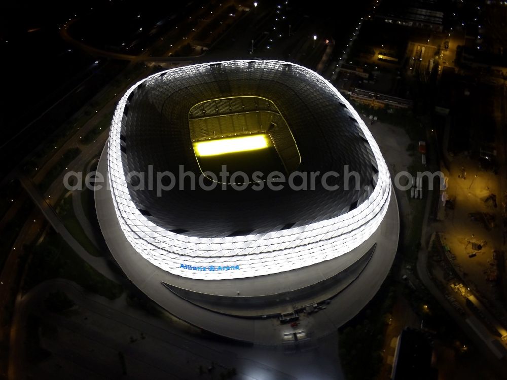 München at night from the bird perspective: Night lighting sports facility grounds of the Arena stadium Allianz Arena on Werner-Heisenberg-Allee in Munich in the state Bavaria, Germany