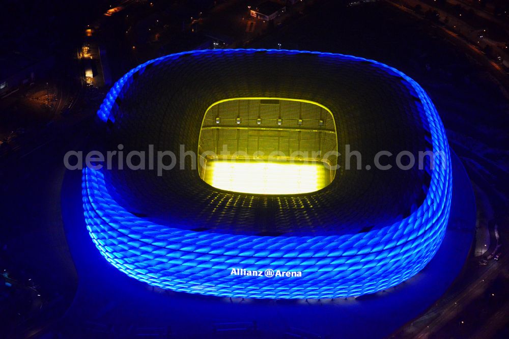 München at night from the bird perspective: Night lighting sports facility grounds of the Arena stadium Allianz Arena on Werner-Heisenberg-Allee in Munich in the state Bavaria, Germany