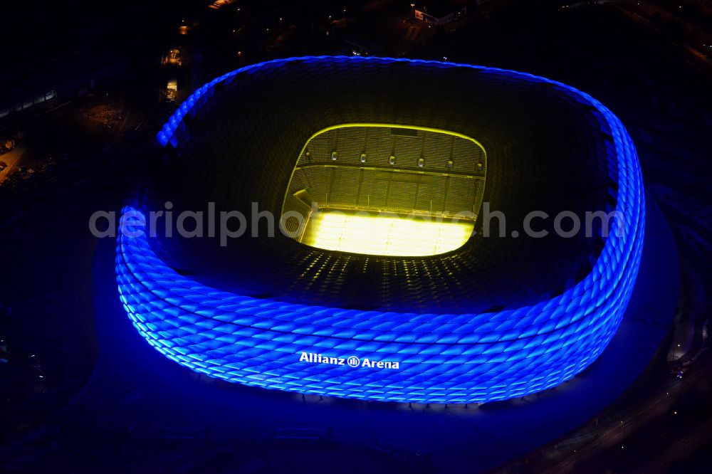 Aerial image at night München - Night lighting sports facility grounds of the Arena stadium Allianz Arena on Werner-Heisenberg-Allee in Munich in the state Bavaria, Germany