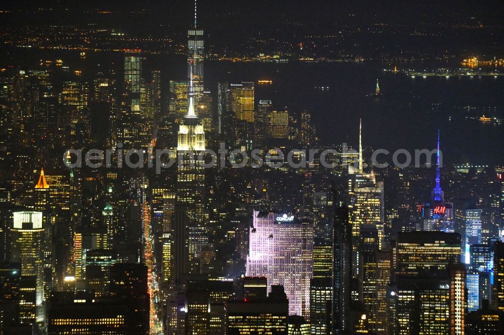 Aerial photograph at night New York - Night lighting City center with the skyline in the downtown area on Broadway in the district Manhattan in New York in United States of America