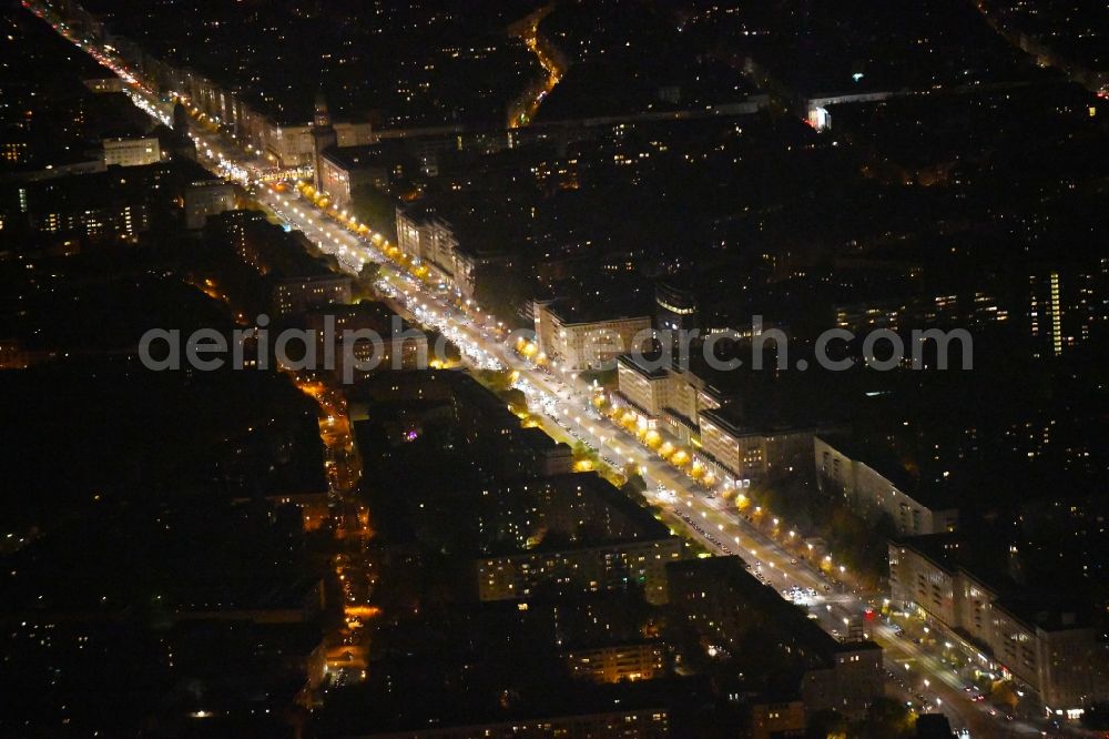 Aerial image at night Berlin - Night lighting Street guide of famous promenade and shopping street Karl-Marx-Allee in the district Mitte in Berlin, Germany