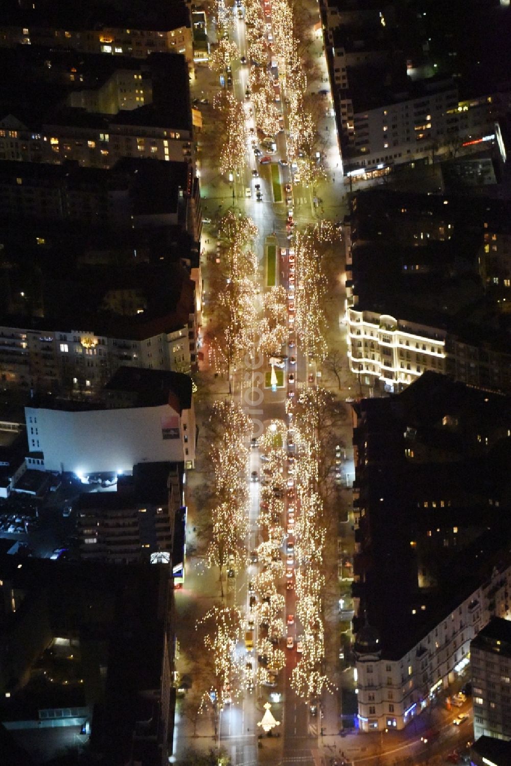 Aerial image at night Berlin - Night vies street guide of famous promenade and shopping street Kurfuerstendamm with illuminated trees in the district Charlottenburg-Wilmersdorf in Berlin