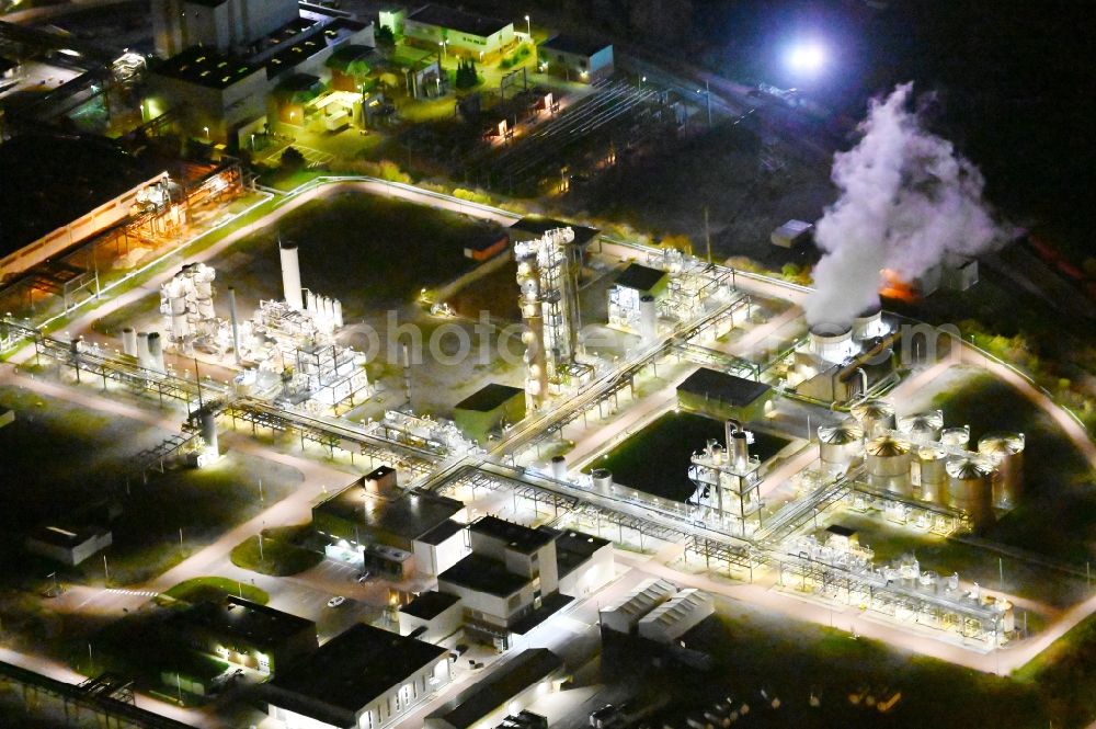 Bernburg (Saale) at night from the bird perspective: Night lighting technical facilities in the industrial area of Industriepark Solvay in Bernburg (Saale) in the state Saxony-Anhalt, Germany