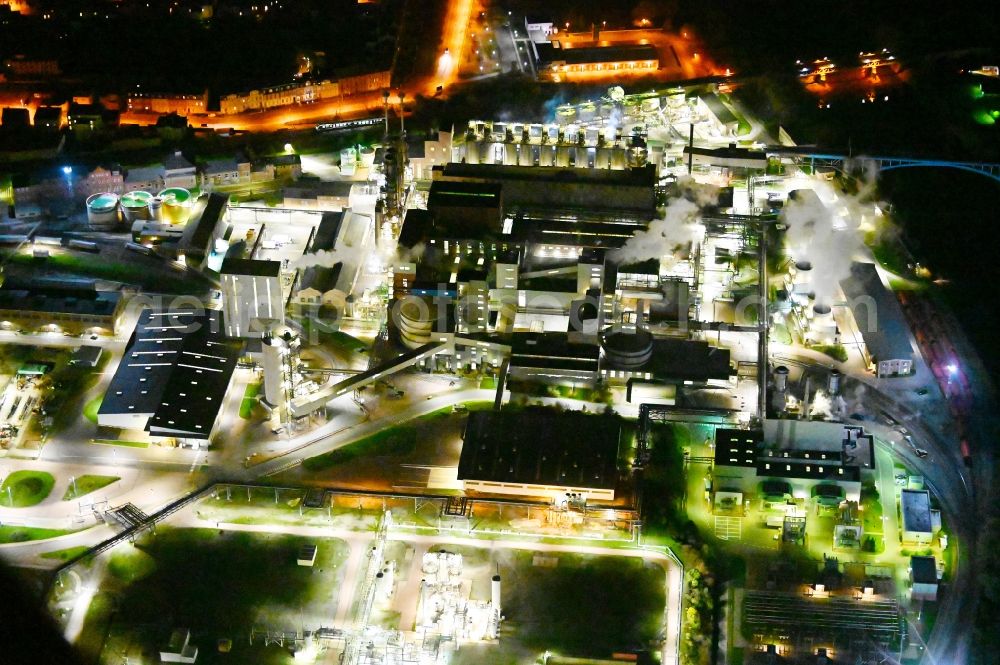 Aerial image at night Bernburg (Saale) - Night lighting technical facilities in the industrial area of Industriepark Solvay in Bernburg (Saale) in the state Saxony-Anhalt, Germany