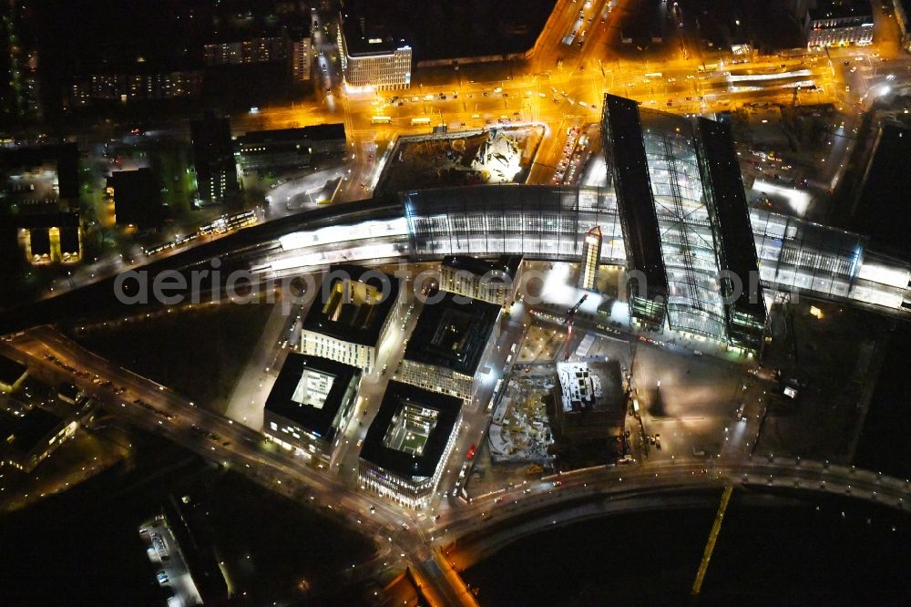 Aerial image at night Berlin - Night lighting Riparian zones on the course of the river of Spree on Central Station in the district Mitte in Berlin, Germany