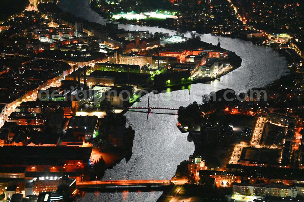 Aerial photograph at night Berlin - Night lighting riparian zones on the course of the river of Spree River on street Obrikatstrasse in the district Schoeneweide in Berlin, Germany