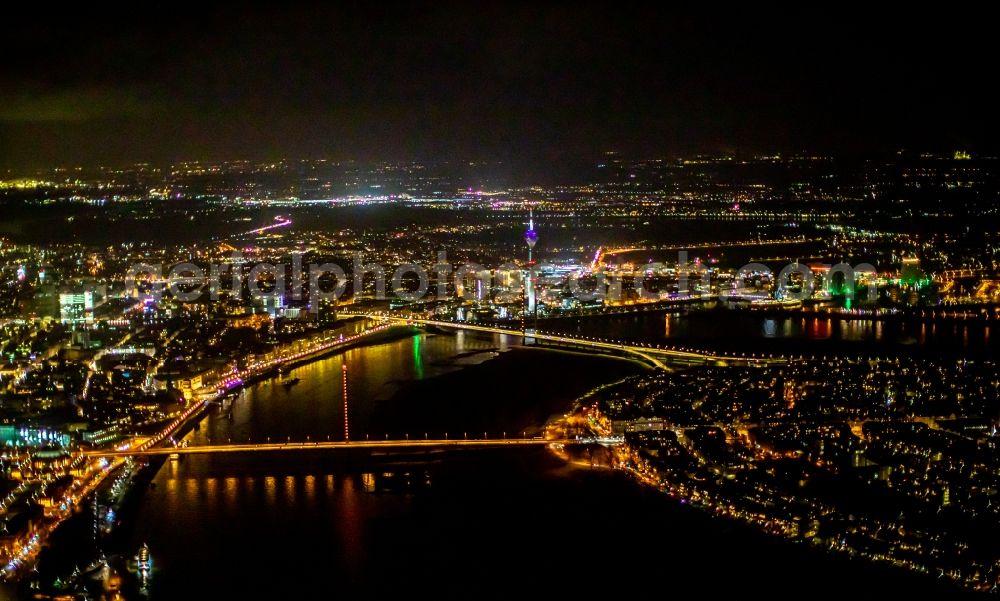 Aerial image at night Düsseldorf - Night lighting curved loop of the riparian zones on the course of the river of the Rhine river in Duesseldorf in the state North Rhine-Westphalia, Germany