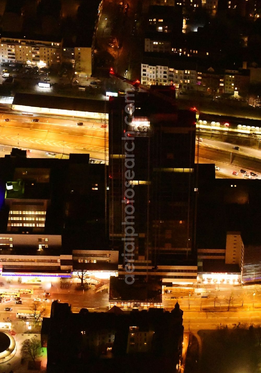 Berlin at night from the bird perspective: Night lighting highrise building of the Steglitzer Kreisel - UeBERLIN Wohntower complex on Schlossstrasse in the district of Steglitz in Berlin